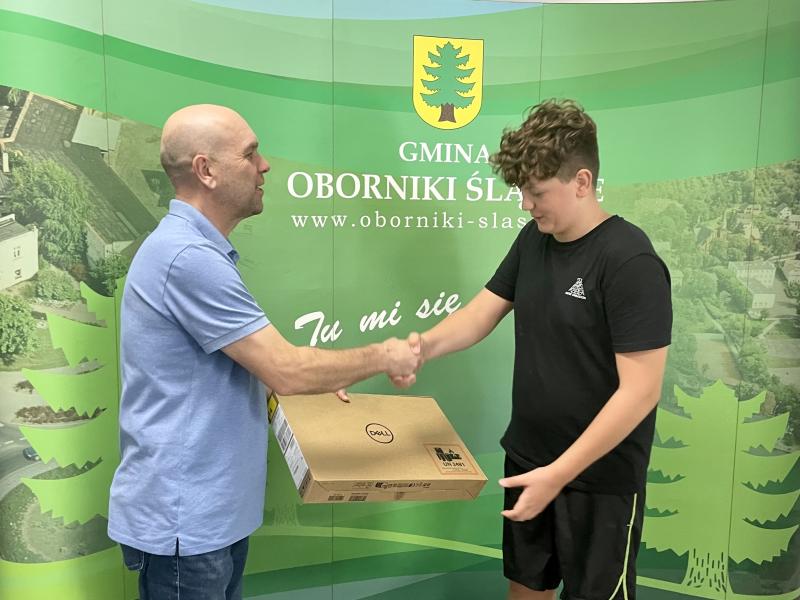 Burmistrz Arkadiusz Poprawa przekazuje laptopa 