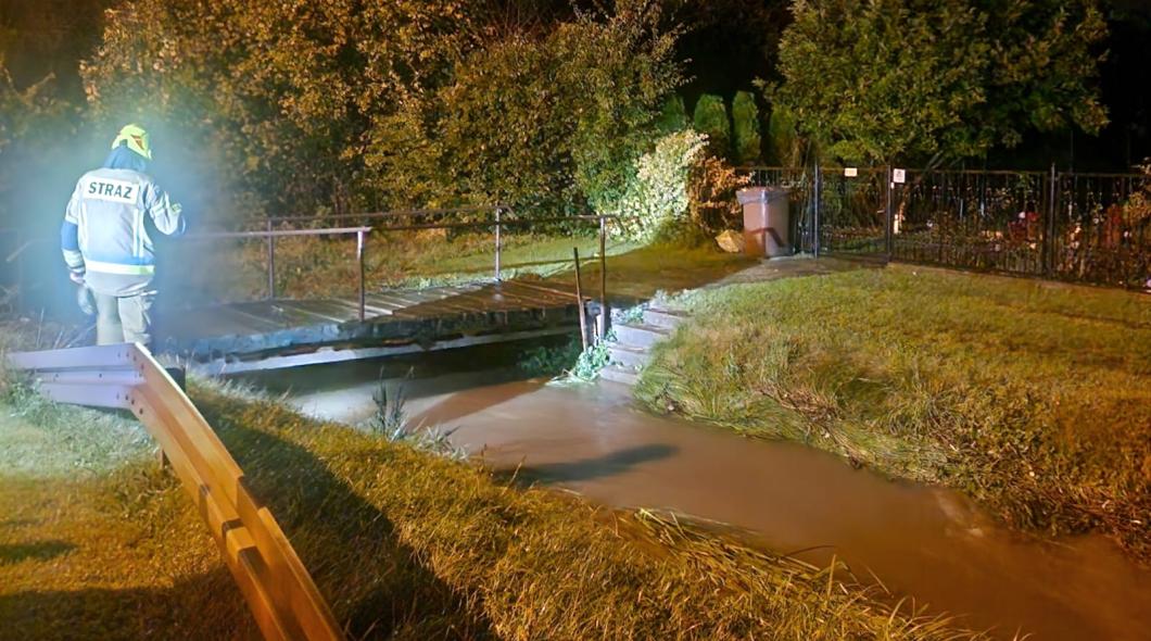 strażak sprawdza poziom wody w rzece