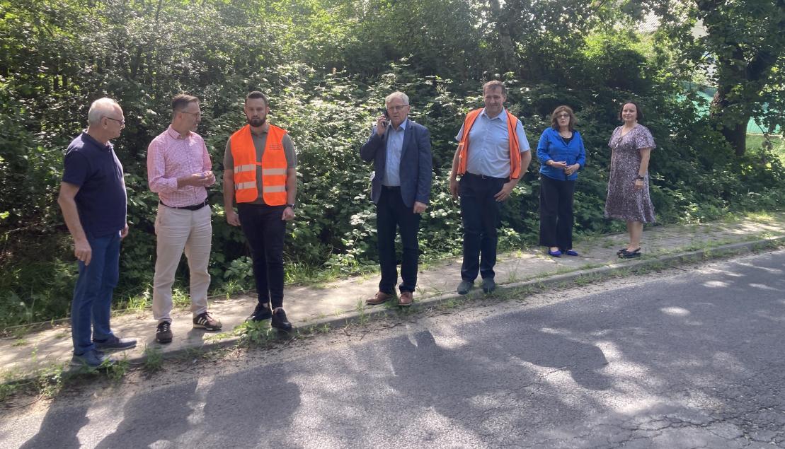 radni i zastępca burmistrza stoją przy drodze