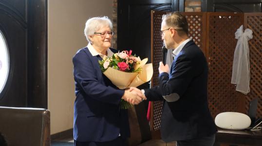 Pani Irena Kowalska przyjmuje gratulacje i kwiaty od zastępcy burmistrza Huberta Oziminy